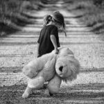 A girls with her teddy bear toy on a dirt road - toy safety for kids