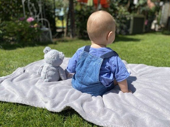 A baby and its teddy bear. Here are some must-have toys for 1 to 2 year olds.
